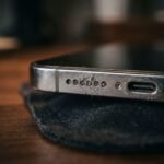 Close-up of iPhone speaker grille and charging port resting on fabric