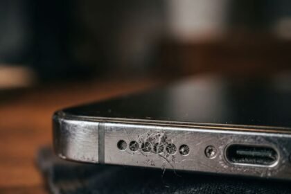 Close-up of iPhone speaker grille and charging port resting on fabric