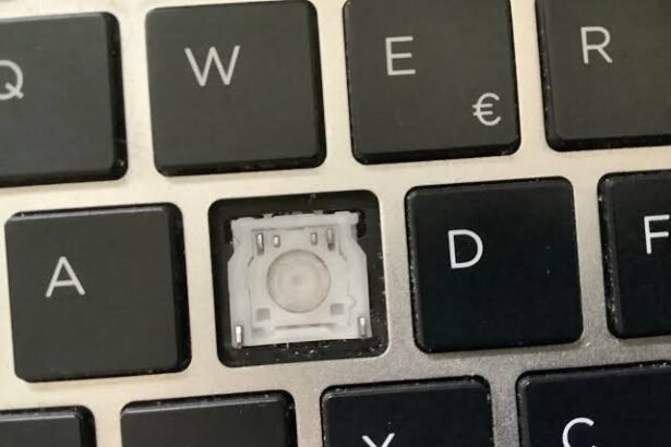 Close-up of a laptop keyboard with the S key removed, showing the switch mechanism underneath