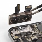 Technician removing a smartphone dual camera module with tweezers during repair