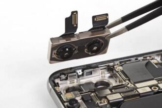 Technician removing a smartphone dual camera module with tweezers during repair