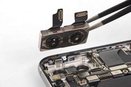 Technician removing a smartphone dual camera module with tweezers during repair